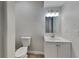 Neat bathroom featuring a toilet, vanity with sink, mirror, and updated lighting at 2352 Benson Rdg, Lithonia, GA 30058