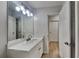 Bathroom features a large mirror with modern lighting and white cabinets at 2352 Benson Rdg, Lithonia, GA 30058