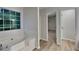 Bright bathroom featuring a modern tub under a bright window, with tile surround and updated fixtures at 2352 Benson Rdg, Lithonia, GA 30058