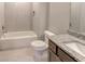 Clean bathroom with tiled tub, toilet, and granite sink at 3066 Reserve Ct Sw, Conyers, GA 30094