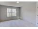 Bright bedroom with neutral carpet, walls, trim, and window with outside view at 3066 Reserve Ct Sw, Conyers, GA 30094