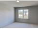 Bedroom featuring neutral carpet, walls, trim, and window with view of the yard and house at 3066 Reserve Ct Sw, Conyers, GA 30094