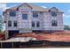 Construction of a new two-story home with architectural details and window installations in a landscaped community at 3066 Reserve Ct Sw, Conyers, GA 30094