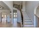 Grand two-story foyer with curved staircase, hardwood floors, and abundant natural light at 3066 Reserve Ct Sw, Conyers, GA 30094