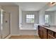 Well-lit bathroom featuring a soaking tub, separate shower, and vanity with granite counters at 3168 Sag Harbor Ct, Buford, GA 30519
