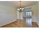 Dining room featuring wainscoting and a chandelier over hardwood floors at 3168 Sag Harbor Ct, Buford, GA 30519