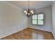 Dining room with wainscoting, chandelier, and a large window offering natural light at 3168 Sag Harbor Ct, Buford, GA 30519