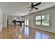 Open-concept kitchen and living room with hardwood floors, white cabinets, fireplace and backyard view at 3168 Sag Harbor Ct, Buford, GA 30519