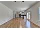 Spacious kitchen and living room featuring white cabinets, hardwood floors and stainless appliances at 3168 Sag Harbor Ct, Buford, GA 30519