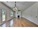 Spacious living room with hardwood floors, fireplace, ceiling fan, and doors leading to outdoor space at 3168 Sag Harbor Ct, Buford, GA 30519