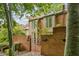 Two-story brick townhouse with a gated brick patio, window-lined sunroom and lush landscaping at 68 Willow Ne Gln, Atlanta, GA 30342