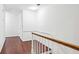 Bright hallway featuring hardwood floors, white walls, and stairs with a wooden handrail at 68 Willow Ne Gln, Atlanta, GA 30342
