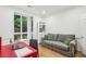 Sun-lit home office with a large window, bright red desk, and a comfortable sitting area with sofa at 68 Willow Ne Gln, Atlanta, GA 30342