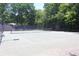 Well-maintained tennis court surrounded by lush trees, providing a private and picturesque setting for play at 68 Willow Ne Gln, Atlanta, GA 30342