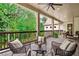 Relaxing back porch with wicker furniture, ceiling fan and view of the backyard and woods at 131 Forsyth Park Ln, Woodstock, GA 30188
