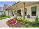 Charming front porch with wood columns, lush landscaping, and elegant lighting, creating a welcoming entrance at 131 Forsyth Park Ln, Woodstock, GA 30188