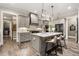 Modern kitchen with a large island, stainless steel appliances, and stylish pendant lighting at 131 Forsyth Park Ln, Woodstock, GA 30188