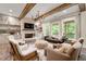 Cozy living room with stone fireplace, beamed ceiling, and an abundance of natural light at 131 Forsyth Park Ln, Woodstock, GA 30188