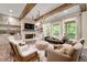 Inviting living room with exposed wooden beams, fireplace, and large windows at 131 Forsyth Park Ln, Woodstock, GA 30188
