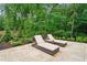 Outdoor patio with stone pavers and two lounge chairs, a great spot for relaxing and enjoying the natural surroundings at 131 Forsyth Park Ln, Woodstock, GA 30188