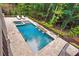 Stunning aerial view of a backyard pool and spa surrounded by lush greenery and mature trees at 131 Forsyth Park Ln, Woodstock, GA 30188