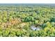 Expansive aerial view of the estate featuring a pristine white house, horse-training paddock, and surrounded by dense forest at 2203 Arbor Hill Rd, Canton, GA 30115