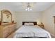 Cozy bedroom featuring a ceiling fan, queen bed, and a dresser with ornate details at 2203 Arbor Hill Rd, Canton, GA 30115
