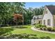 Well-maintained home with a manicured front yard, mature trees, and a charming front porch with space to sit at 2203 Arbor Hill Rd, Canton, GA 30115