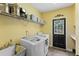 Practical laundry room with a sink, washer, dryer, storage shelves, and exterior access at 2203 Arbor Hill Rd, Canton, GA 30115