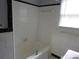 Bright bathroom featuring white tiling, a bathtub with shower, and window allowing natural light at 244 Hilltop Sw Dr, Atlanta, GA 30315