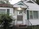 Close-up of the front door with green trim and a small porch with iron handrails at 244 Hilltop Sw Dr, Atlanta, GA 30315