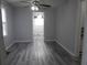 A view of a room with gray-toned walls and wood-look floors, ceiling fan and a doorway at 244 Hilltop Sw Dr, Atlanta, GA 30315