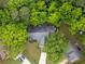 Aerial view of a home surrounded by lush trees, featuring a driveway and well-maintained landscaping at 245 Scotch Pine Ct, Alpharetta, GA 30022