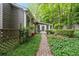 Charming backyard featuring a brick walkway surrounded by lush greenery and mature trees at 245 Scotch Pine Ct, Alpharetta, GA 30022