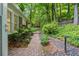 Charming backyard featuring a brick walkway surrounded by lush greenery and mature trees at 245 Scotch Pine Ct, Alpharetta, GA 30022