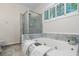 Relaxing bathroom with a marble-enclosed tub, shutters, and separate shower at 245 Scotch Pine Ct, Alpharetta, GA 30022