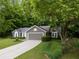 Exterior view of home with green landscaping, trees, driveway, and an attached two-car garage at 245 Scotch Pine Ct, Alpharetta, GA 30022