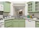 Close-up shot of granite counters and green cabinetry in the kitchen at 245 Scotch Pine Ct, Alpharetta, GA 30022