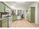The kitchen features green cabinets, granite counters, and stainless appliances at 245 Scotch Pine Ct, Alpharetta, GA 30022