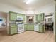 A well-lit kitchen features green cabinets, granite counters, and stainless appliances at 245 Scotch Pine Ct, Alpharetta, GA 30022
