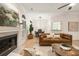Cozy living room featuring fireplace, modern furniture, and a view into the dining room at 245 Scotch Pine Ct, Alpharetta, GA 30022