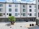 A modern townhome with gray and white siding, a brick foundation, and a paved courtyard and garage at 701 Pryor Sw St # 5, Atlanta, GA 30315