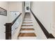 A modern staircase features wood treads, steel cable railings, and abundant natural light from the bedroom beyond at 701 Pryor Sw St # 5, Atlanta, GA 30315