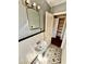 Neutral bathroom with pedestal sink, tiled walls, patterned flooring, and open storage at 1386 Bluefield Sw Dr, Atlanta, GA 30310