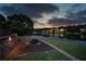 Inviting backyard with lake view, fire pit, Adirondack chairs, retaining wall with lighting, and manicured lawn at 1608 Mulberry Lake Dr, Dacula, GA 30019