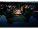 Idyllic backyard with lighted pool, tiered landscaping, fire pit, and lake access at dusk at 1608 Mulberry Lake Dr, Dacula, GA 30019