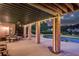 Spacious covered patio with brick columns, seating, and views of the pool, putting green, and lake at 1608 Mulberry Lake Dr, Dacula, GA 30019