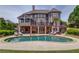 Beautiful backyard featuring a kidney-shaped pool, lounge chairs, and covered patio with exterior access to the home at 1608 Mulberry Lake Dr, Dacula, GA 30019