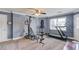 Home gym area with fitness equipment, carpet flooring, a ceiling fan, and a bright window with natural light at 1608 Mulberry Lake Dr, Dacula, GA 30019