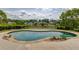Backyard view of an in-ground pool with a putting green and lake in the background at 1608 Mulberry Lake Dr, Dacula, GA 30019